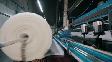 Baston olmayan malzemelerin üretimi yakın plan. Sentetik kışlık üretim fabrikası. Syntepon üretim süreci.