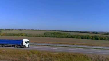Kamyon otoyolda gidiyor. Kamyon tarlaların etrafındaki otoyolda gidiyor..