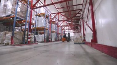 Forklift kullanan bir işçi bir depoda çalışacaktır. Büyük, modern bir depo. Depo çalışması.