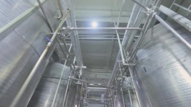 Gıda endüstrisindeki büyük konteynırlar. Dondurma endüstrisindeki parlak metal kaplar. Endüstriyel iç mekan. Gıda üretimi.