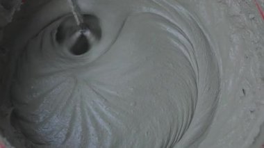 Mixing mortar in a bucket. The mortar is kneaded in a bucket with a mixer.