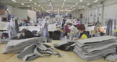 Büyük dikiş atölyesi. Terziler fabrikada kıyafet yaparlar. Giysi fabrikası. Kıyafet üretim atölyesi.