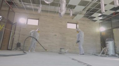 İnşaat alanında beton zeminde çalışıyorum. İnşaat alanında çalışma süreci. İşçiler beton döşeme yapıyor.