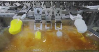 Ice cream is dipped into a container with fruit glaze. Colorful bright ice cream on the conveyor. Ice cream production.