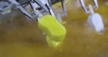 Ice cream is dipped into a container with fruit glaze. Colorful bright ice cream on the conveyor. Ice cream production.