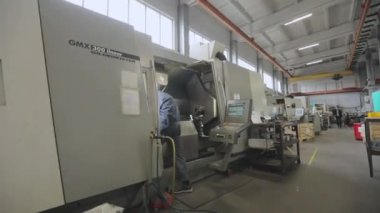 İşçi modern bir CNC makinesinde çalışıyor. CNC makineli modern atölye. CNC makinesinde çalışan bir adam. Modern fabrika.