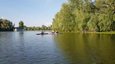 Girls do sports exercises on the sup board. Physical exercises on the sup board. Sports recreation on the river. Water sports.