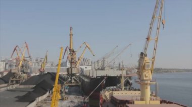 Hızla gemiden vinçlerle kömür boşaltılıyor. Gemi limandaki vinçlerle boşaltıldı. Ukrayna limanında gemiler.
