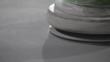 Processing a concrete floor with a grinder close-up. Grinding concrete floor large plan. Construction site equipment close-up.