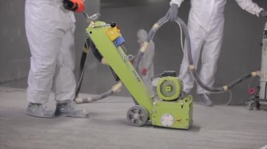 Processing a concrete floor with a grinder close-up. Grinding concrete floor large plan. Construction site equipment close-up.