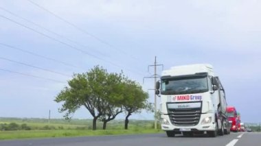 Otoyol boyunca giden beyaz bir kamyon. Tankerli bir kamyon güneşli havada otoyola çıkıyor. Bir kamyon konvoyu otoban boyunca gidiyor..