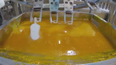 Ice cream is dipped into a container with fruit glaze. Colorful bright ice cream on the conveyor. Ice cream production.