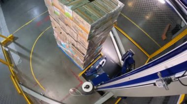 Plastik film kutularını paketliyorum. Kutu germe ambalaj makinesi. Palet ambalaj makinesi. Kutuları bir çemberde plastik bir filme sarmak için makine..