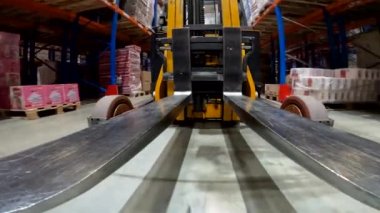 Forklift çatalı yakın çekim. Yük taşıyıcı depoya biniyor. Modern forklift büyük bir depoda..