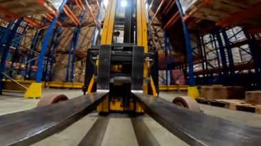 Forklift çatalı yakın çekim. Yük taşıyıcı depoya biniyor. Modern forklift büyük bir depoda..