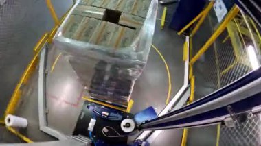 Plastik film kutularını paketliyorum. Kutu germe ambalaj makinesi. Palet ambalaj makinesi. Kutuları bir çemberde plastik bir filme sarmak için makine..