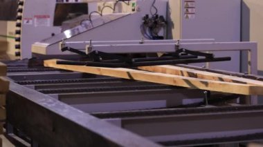 A man works at a sawmill, a workflow at a modern sawmill. Industrial interior woodworking factory.