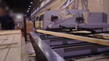 A man works at a sawmill, a workflow at a modern sawmill. Industrial interior woodworking factory.