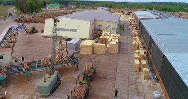 Flying over a large sawmill, the work of machinery on sawmills, flying over the warehouse of logs at the sawmill.