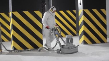 Processing a concrete floor with a grinder close-up. Grinding concrete floor large plan. Construction site equipment close-up.