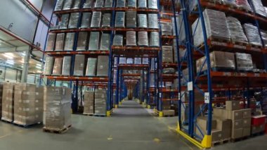 Fabrikanın deposunda özel ekipman var. Depoyu turlayan bir sürü forklift var. Modern yükleyiciler büyük bir depoda..