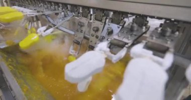 Ice cream is dipped into a container with fruit glaze. Colorful bright ice cream on the conveyor. Ice cream production.