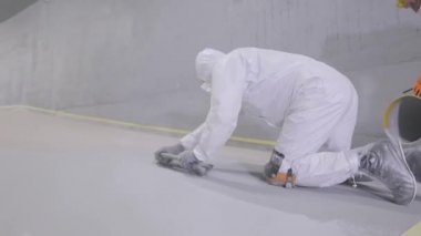 Creating a self-leveling floor in the parking lot. Creation of self-leveling floors. Builders make self-leveling floors in the parking lot.