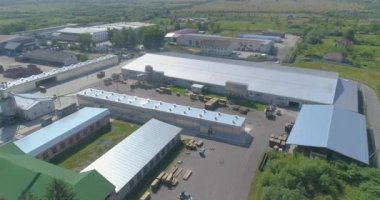 Forklift keresteleri değirmenden geçiyor. Ahşap fabrikası teorisi, üst görüş. Uzman makineler fabrika topraklarında seyahat ederler..