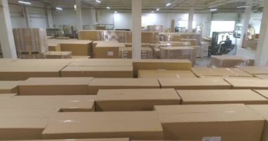 Fabrikada bitmiş ürünlerle dolu büyük bir depo. Fabrikada kutularla dolu bir depo. Büyük bir depodaki bir forklift kutuları taşır..