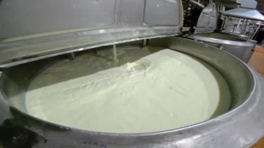 Dondurma hazırlığı. Fabrikada süt karıştırmak. Süt büyük bir fıçıda döner.