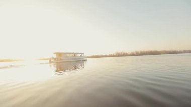 Gün batımında parti teknesi. Parti için eğlence teknesi. Parti teknesi gün batımında nehirde yüzer..
