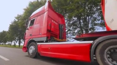 Kamyonlar yol boyunca gidiyor. Tank kamyonu olan bir kamyon otoyol boyunca yaklaşır. Tehlikeli malların nakliyesi.