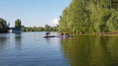 Girls do sports exercises on the sup board. Physical exercises on the sup board. Sports recreation on the river. Water sports.