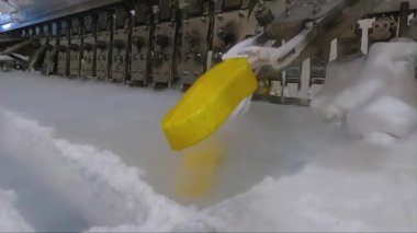 Ice cream is dipped into a container with fruit glaze. Colorful bright ice cream on the conveyor. Ice cream production.