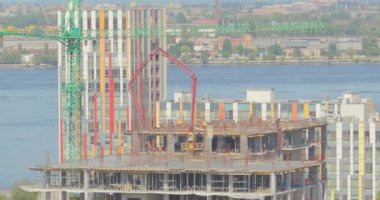 Çok katlı bir binanın şantiyesinde çalışıyorum. İşçiler zaman aşımına uğramış bir ev inşa ediyorlar. Çok katlı bir binanın zaman atlaması inşaatı. İnşaatçılar çok katlı bir zaman atlaması inşa ediyorlar.