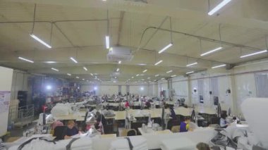 Sewing shop time lapse. Work in a large sewing shop time lapse. Many seamstresses work in the factory. Sewing factory from the inside.