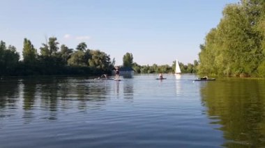 Girls do sports exercises on the sup board. Physical exercises on the sup board. Sports recreation on the river. Water sports.