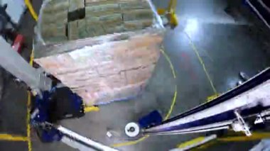 Plastik film kutularını paketliyorum. Kutu germe ambalaj makinesi. Palet ambalaj makinesi. Kutuları bir çemberde plastik bir filme sarmak için makine..