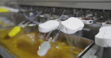 Ice cream is dipped into a container with fruit glaze. Colorful bright ice cream on the conveyor. Ice cream production.