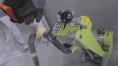 İnşaatçılar zemini özel ekipmanlarla cilalıyorlar. Beton yüzey öğütme. İnşaat alanında inşaatçılar.