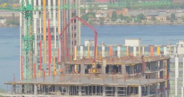 Çok katlı bir binanın şantiyesinde çalışıyorum. İşçiler zaman aşımına uğramış bir ev inşa ediyorlar. Çok katlı bir binanın zaman atlaması inşaatı. İnşaatçılar çok katlı bir zaman atlaması inşa ediyorlar.