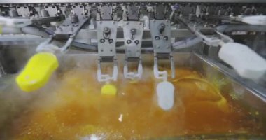 Ice cream is dipped into a container with fruit glaze. Colorful bright ice cream on the conveyor. Ice cream production.
