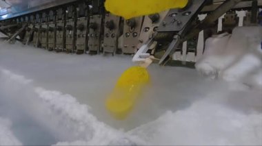 Ice cream is dipped into a container with fruit glaze. Colorful bright ice cream on the conveyor. Ice cream production.