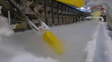 Ice cream is dipped into a container with fruit glaze. Colorful bright ice cream on the conveyor. Ice cream production.