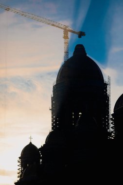 Bükreş, Romanya - 20 Ekim 2021: Catedrala Mantuirii Neamului (Halk Kurtuluş Katedrali) inşaat sahasının silüeti gün doğumunda.