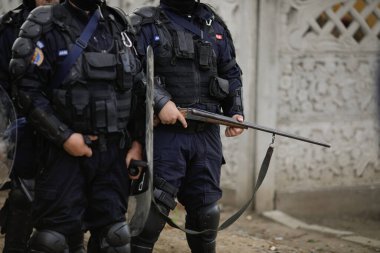 Sarulesti, Romanya - 27 Mayıs 2021: Romen polisi ve çevik kuvvet teçhizatıyla Jandarması, sanayi atıklarını sokağa döken kişileri teşhis etmede yetkilileri korudu.