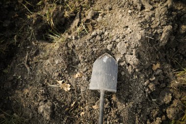 Yüzeyin sığ derinliği (seçici odak) görüntüsü bir parça tarımsal toprak üzerinde metal kürek ile.