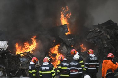 Bükreş, Romanya - 5 Aralık 2021: Romen itfaiyeciler geri dönüşüm merkezinde çıkan yangını söndürmeye çalışıyorlar.