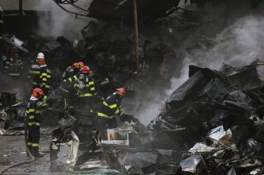 Bükreş, Romanya - 5 Aralık 2021: Romen itfaiyeciler geri dönüşüm merkezinde çıkan yangını söndürmeye çalışıyorlar.