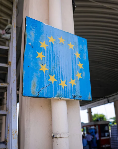 Romanya 'nın Avrupa Birliği sembolüyle olan sınırında yıpranmış ve paslanmış bir tabelayla sığ alan derinliği (seçici odak) resmi.